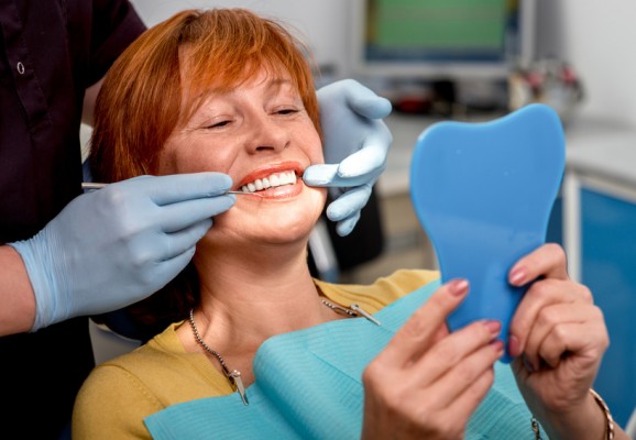 Femme accède aux soins dentaires grâce au zéro reste à charge